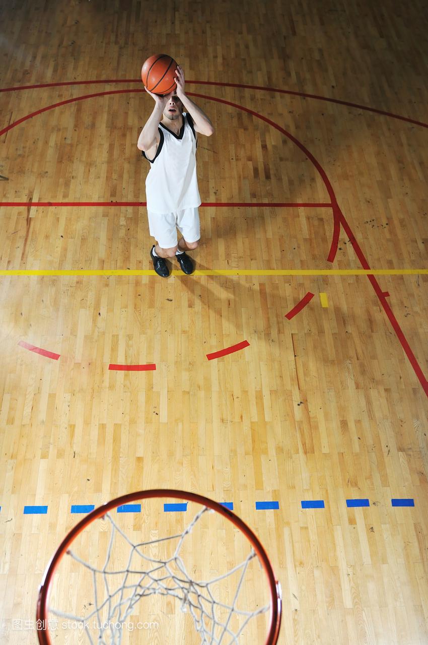一个健康的年轻人在学校体育馆打篮球比赛