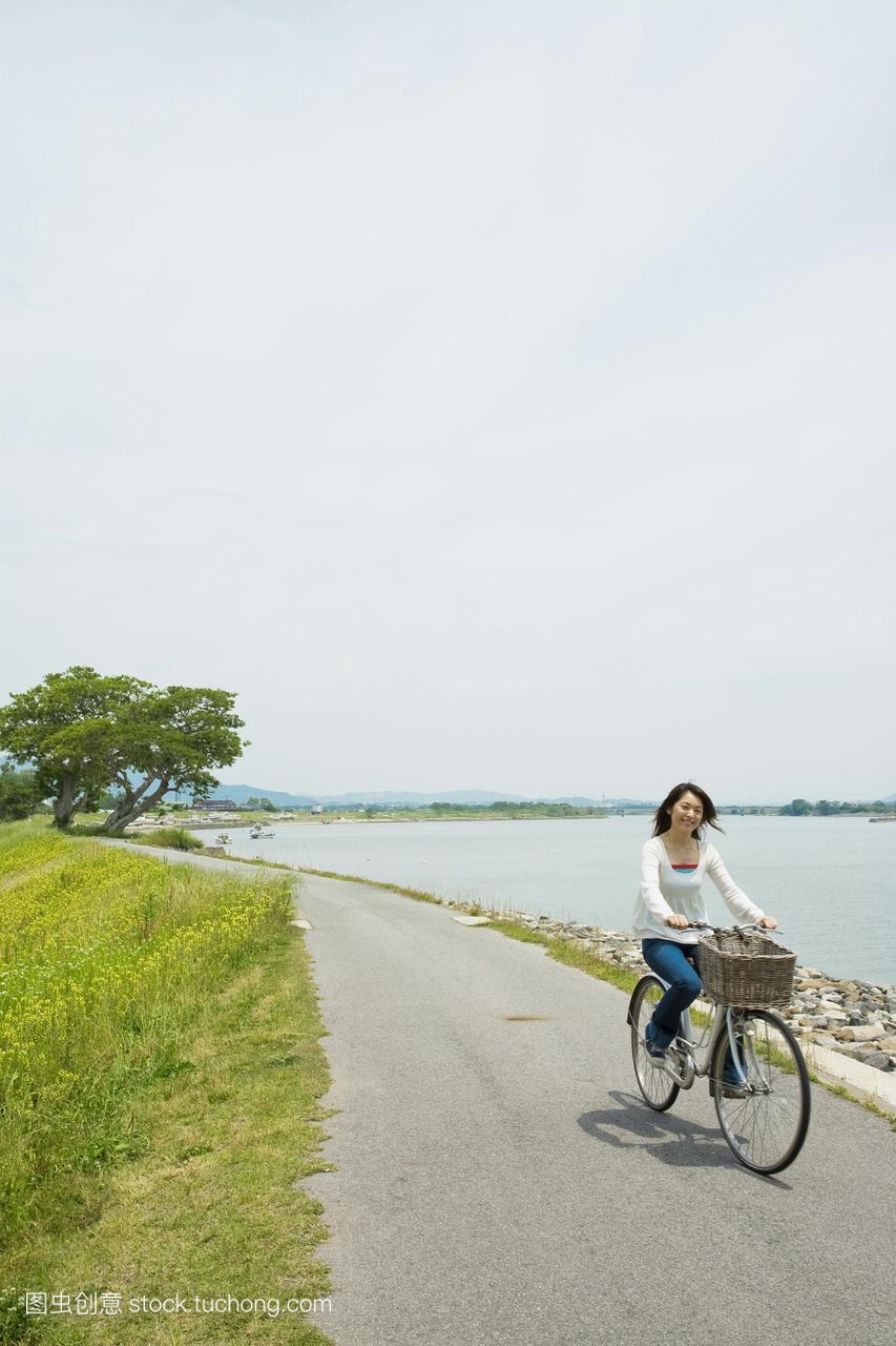 的女人跑沿着大海的一辆自行车