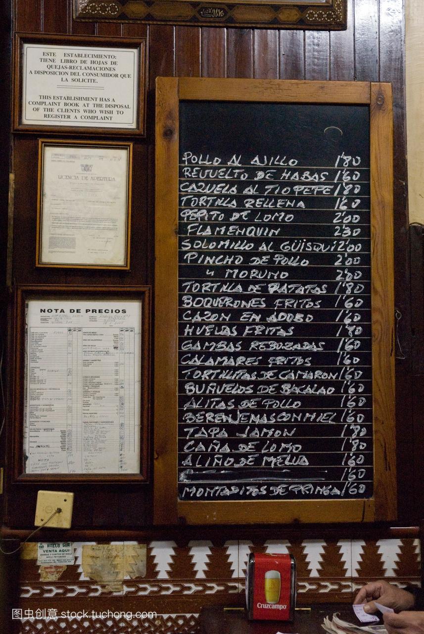在塞维利亚一家酒吧的一块黑板上写着tapas的