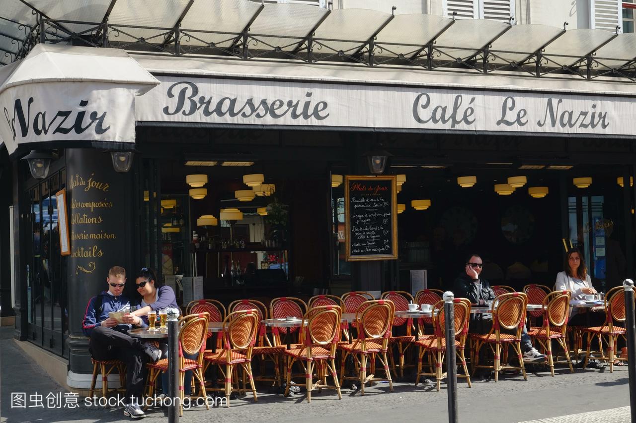人们在巴黎蒙马特区的一个露天咖啡馆里吃东西