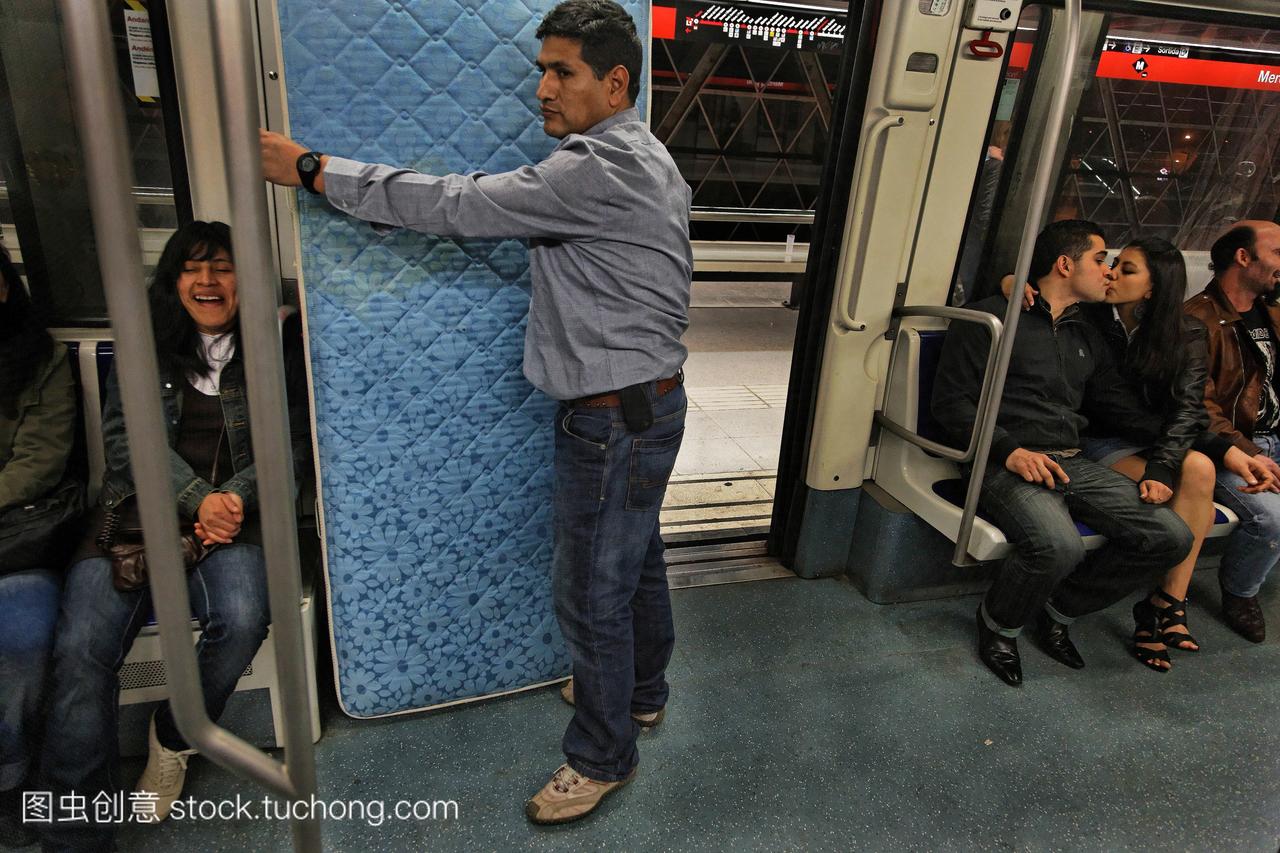 一名男子在巴塞罗那地铁上运输床垫。