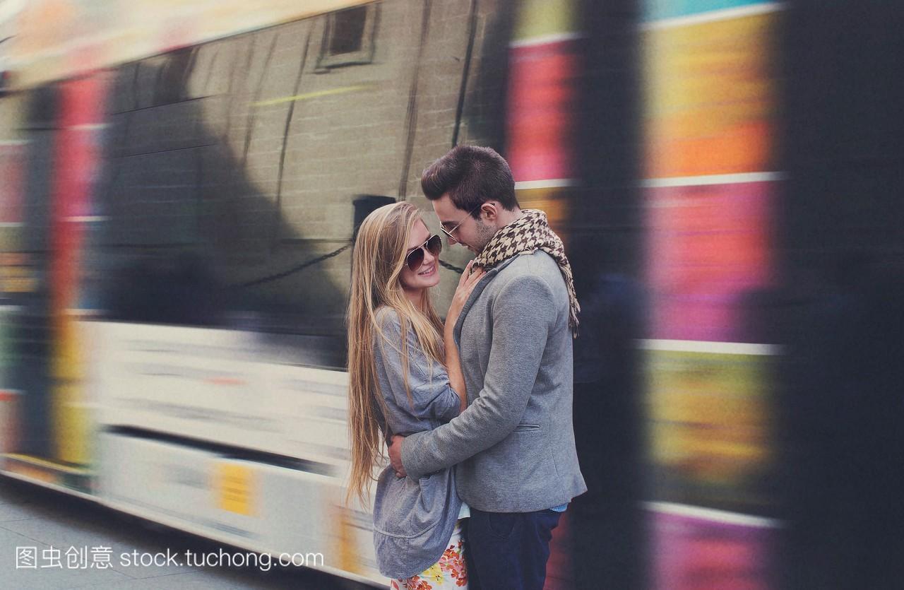 年轻夫妇拥抱在火车站西班牙塞维利亚