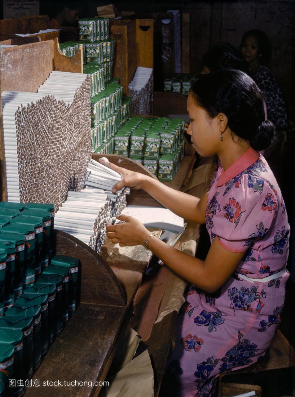 一个女人在香烟工厂在马尼拉工作。