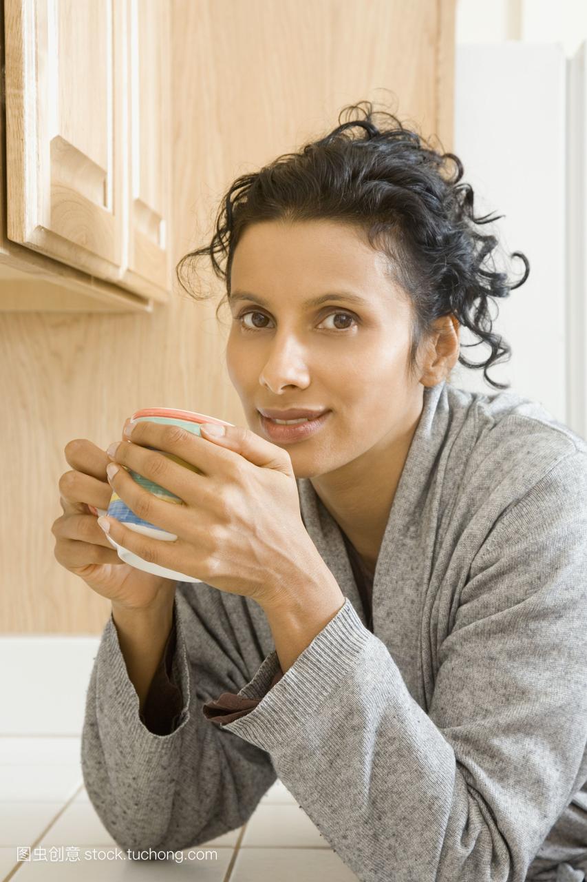 印度女人在厨房里喝咖啡