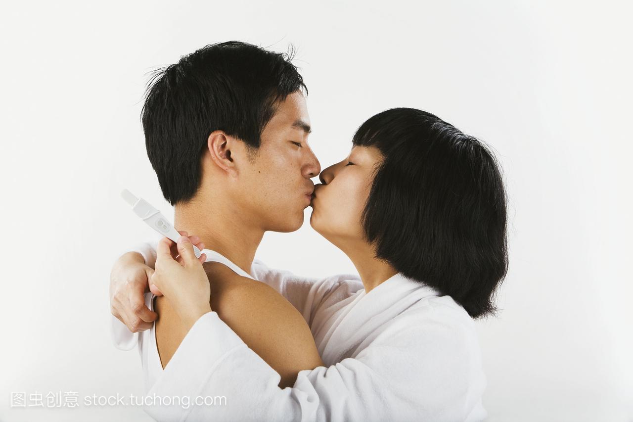 亚洲夫妇接吻和怀孕测试