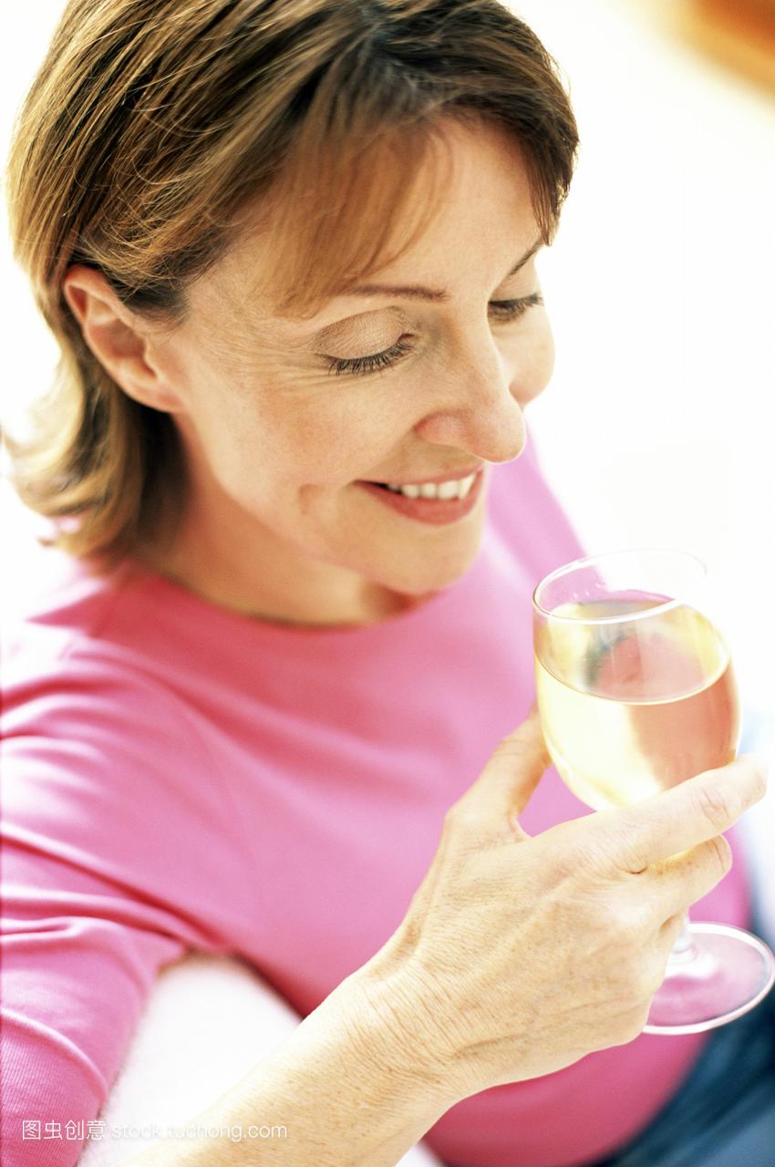 模型发布。喝葡萄酒。女人喝一杯白葡萄酒。