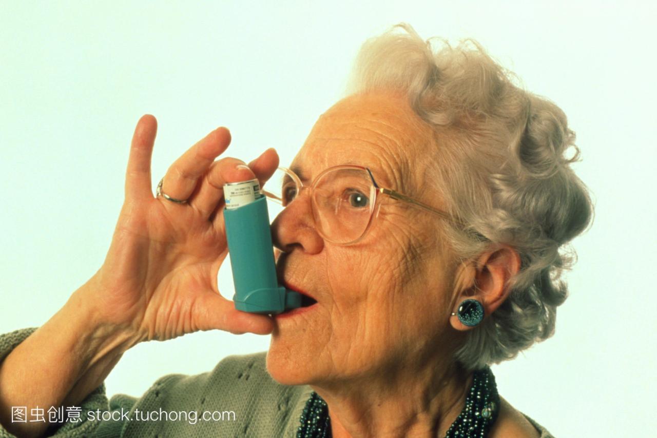 模型发布。哮喘吸入器。侧面的老年妇女使用气