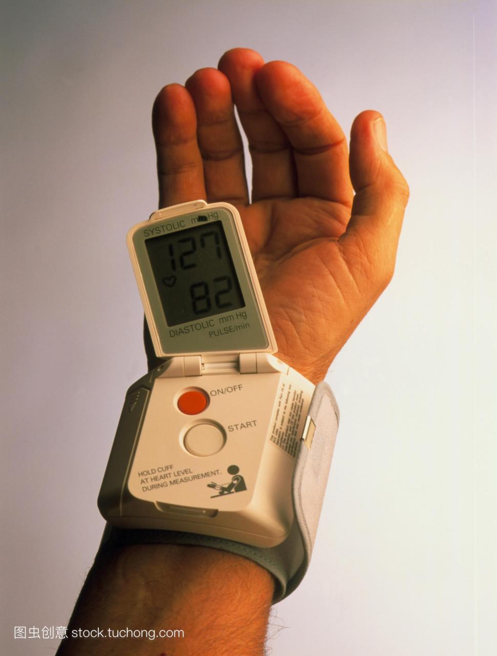 血压测量。人的手腕戴着便携式数字血压计显示