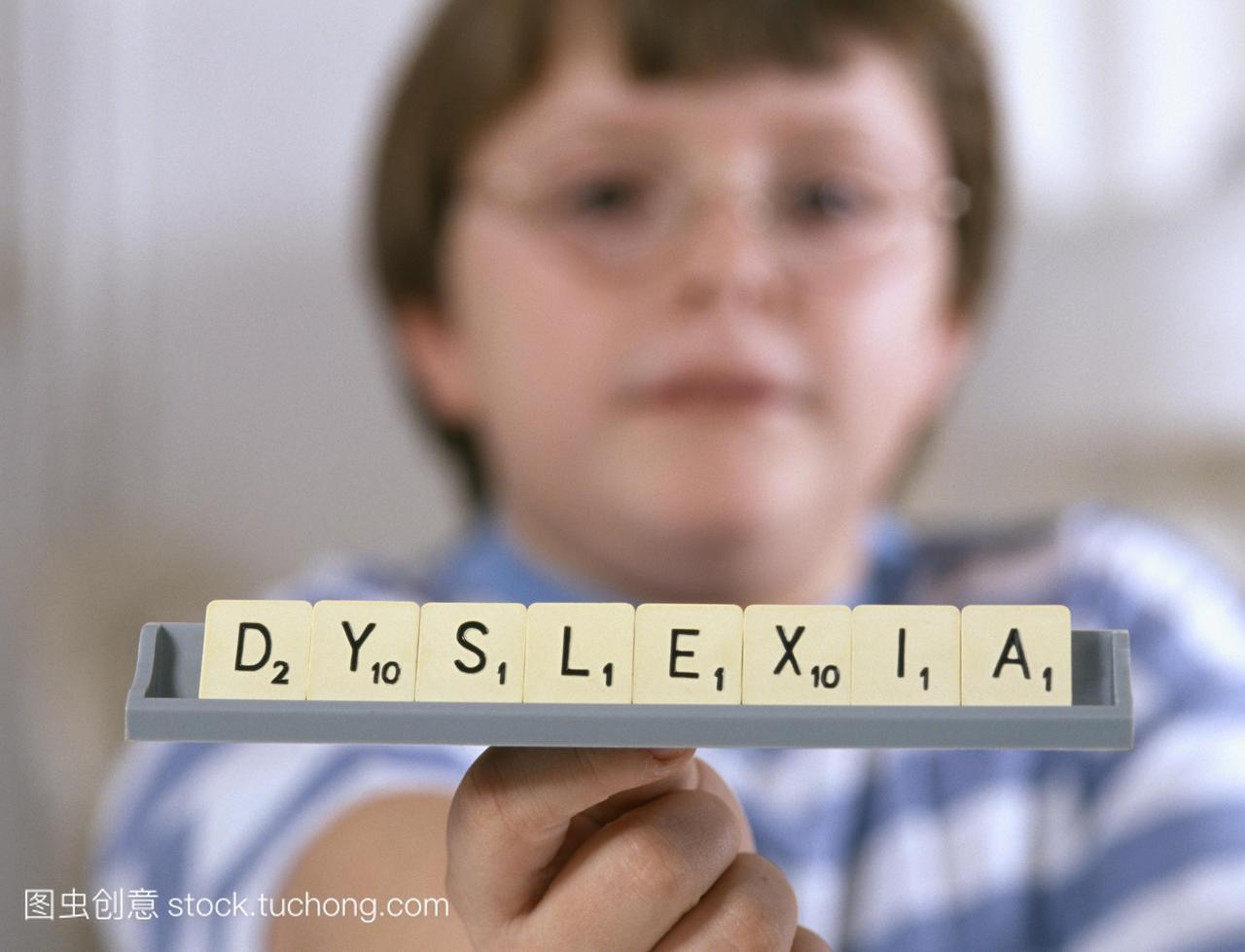 布。难语症。男孩拿着拼字母拼写这个词阅读障
