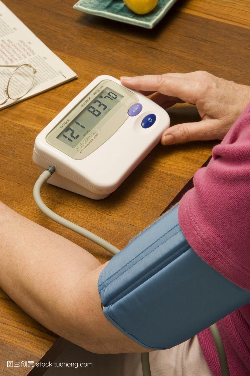 血压测量。女人在家检查她的血压与电子血压计
