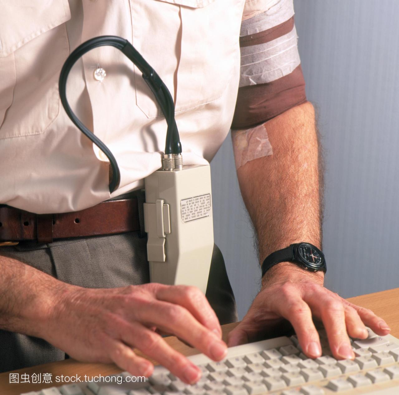 动态血压监测。男子打字时,带着一辆流动血压