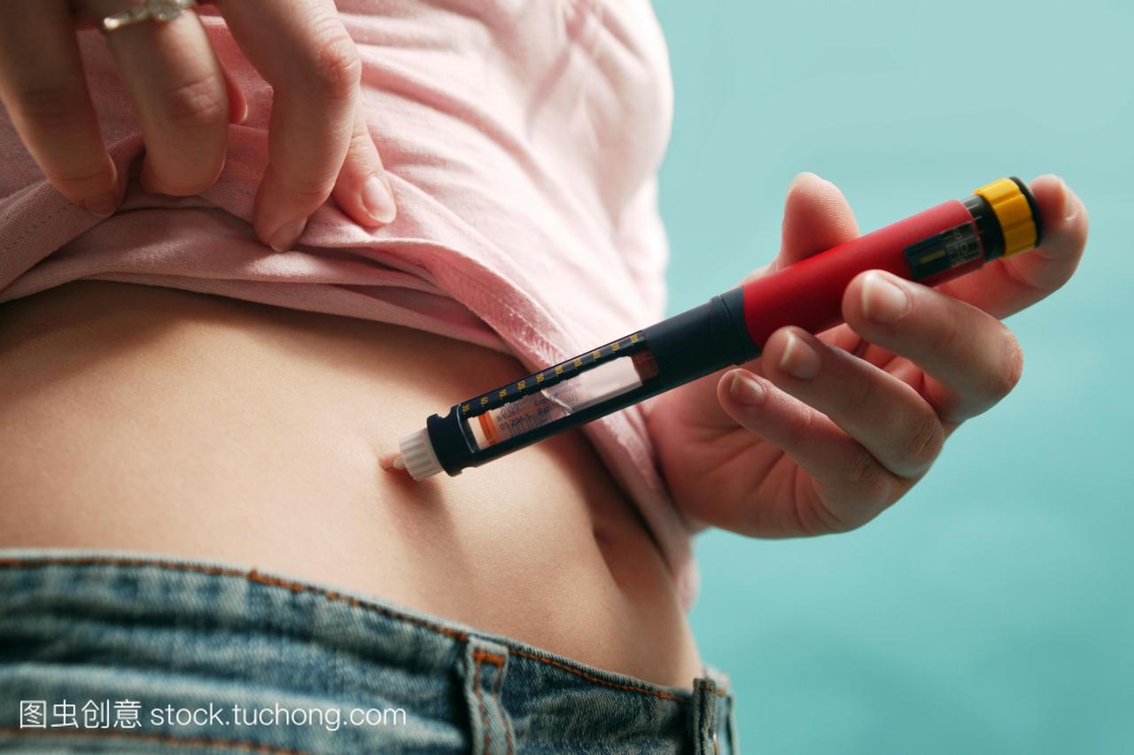 胰岛素注射。糖尿病妇女与胰岛素注入自己的腹