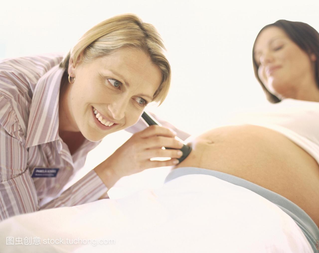 模型发布。产科检查。助产士左用耳鸣压在孕妇