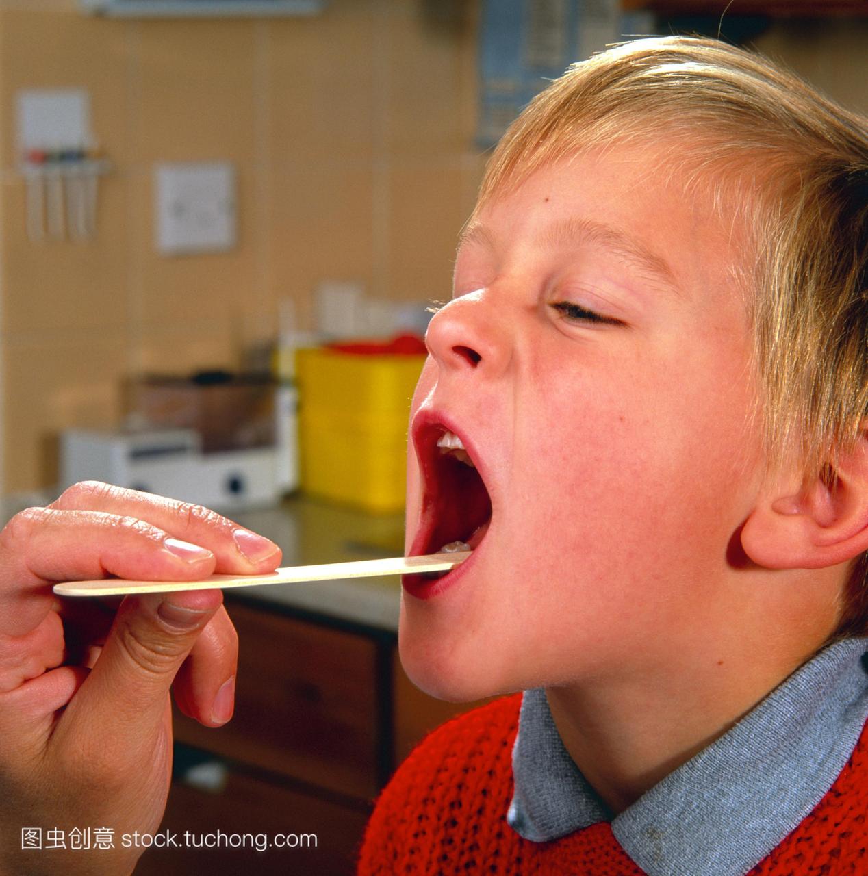 喉咙检查。一个小男孩拥有他的嘴医生检查他的