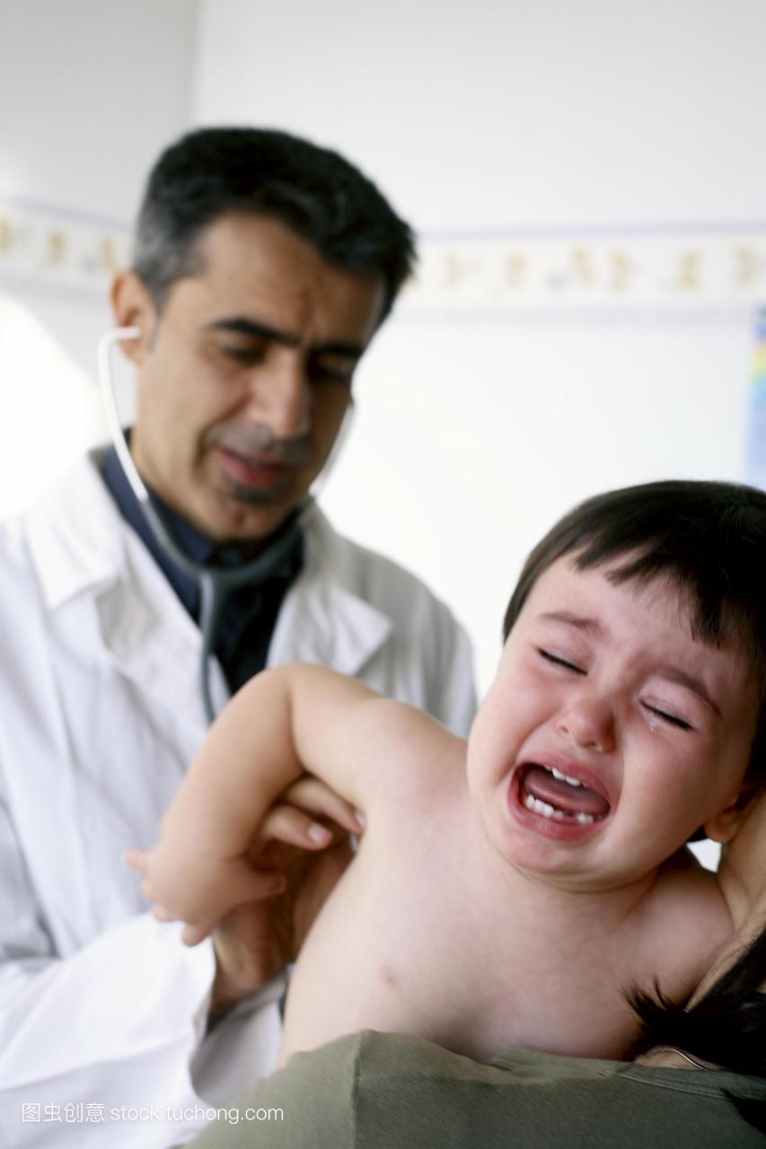 发布。儿科检查。男孩哭了作为一个医生使用听