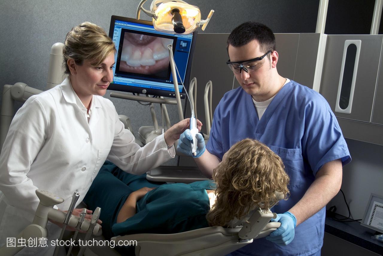 牙科培训。牙医训练学生蓝色衣服牙科设备的使