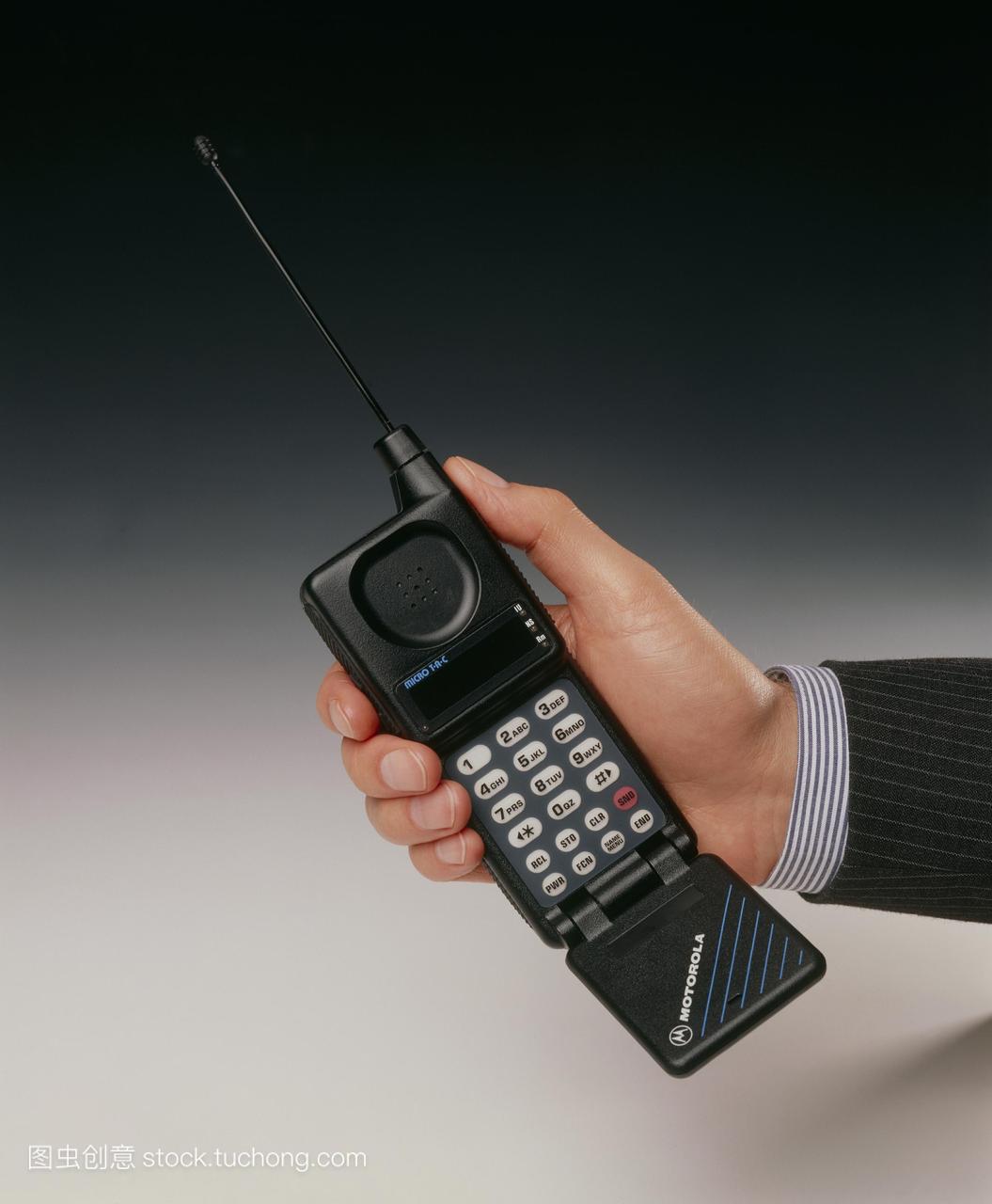 早期的手机。商人手持摩托罗拉的tac手机。