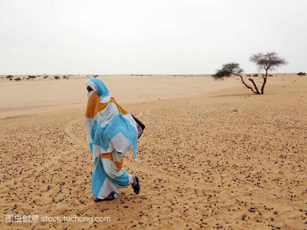 毛里塔尼亚女人走在沙漠