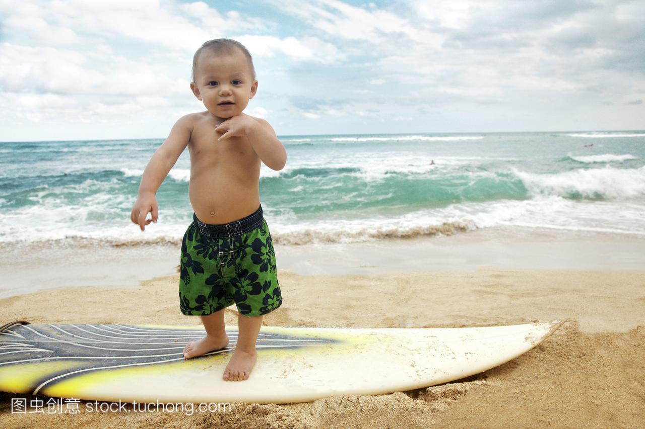 夏威夷,欧胡岛,一个穿着冲浪短裤的蹒跚学步的