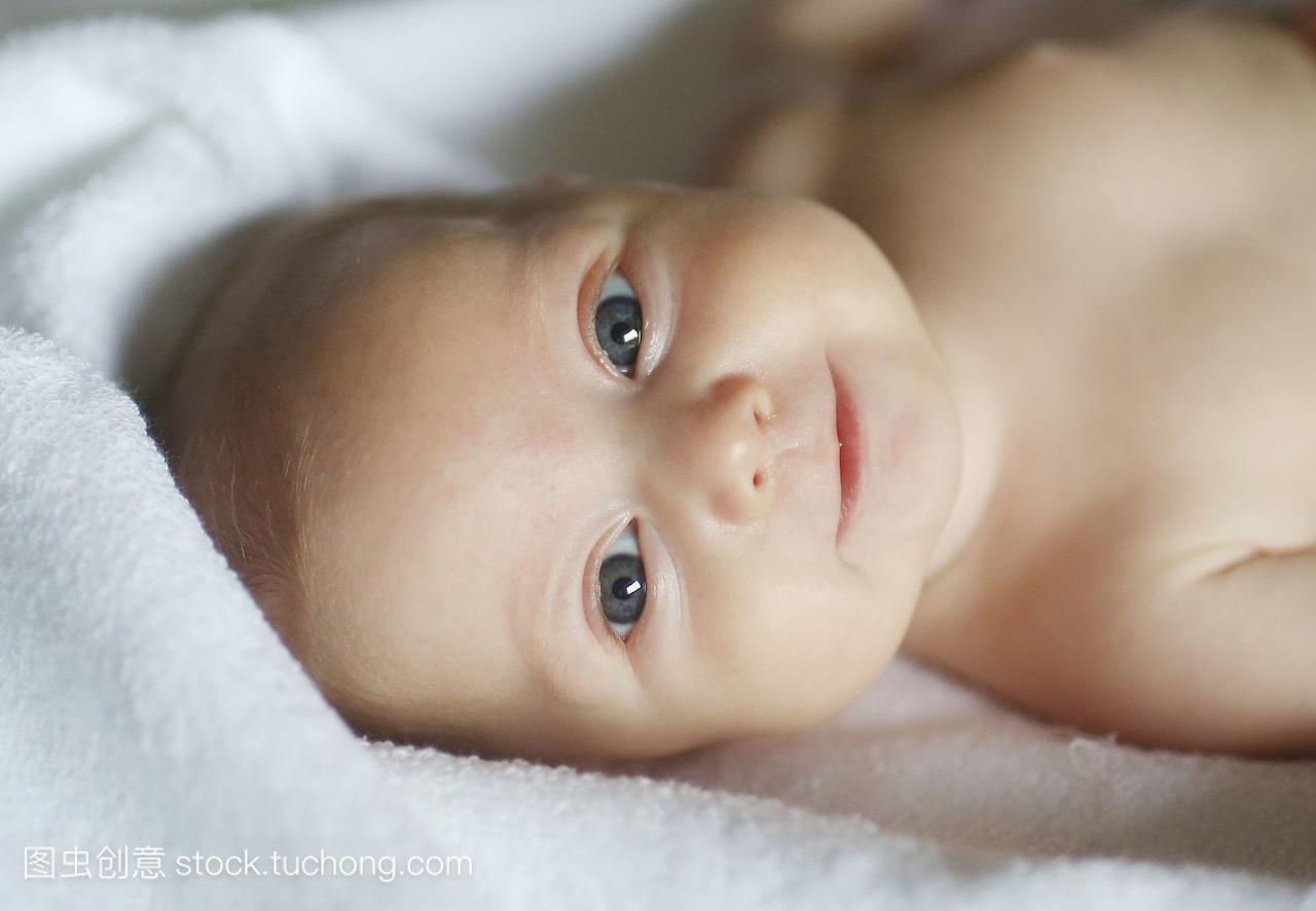一个四个月大的婴儿,躺在一条白毛巾上