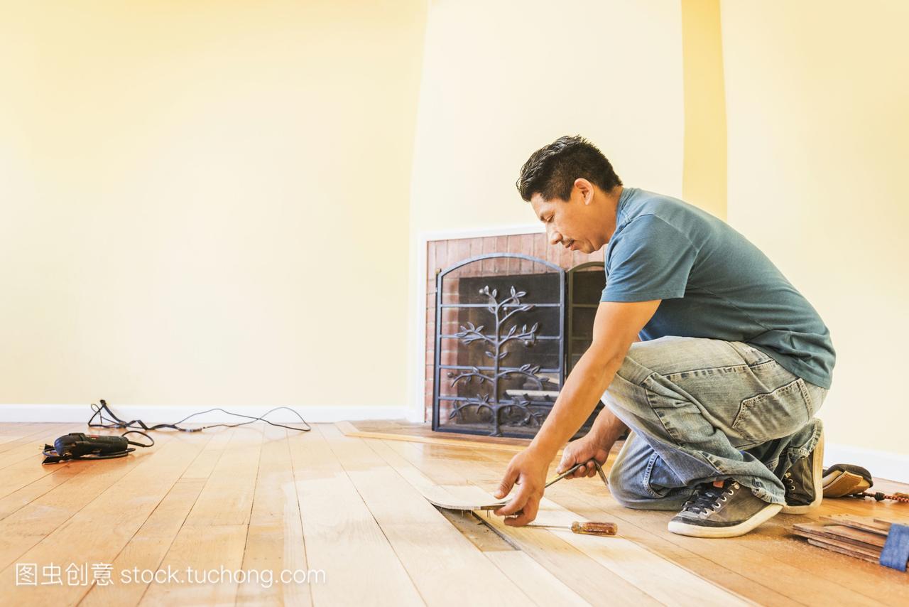 西班牙裔男子在新房子里安装地板