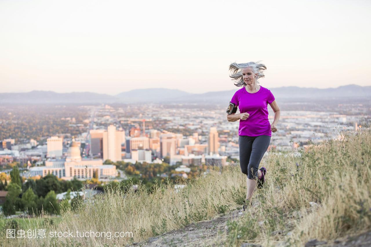 一名白人妇女在美国犹他州盐湖城的山顶上跑步