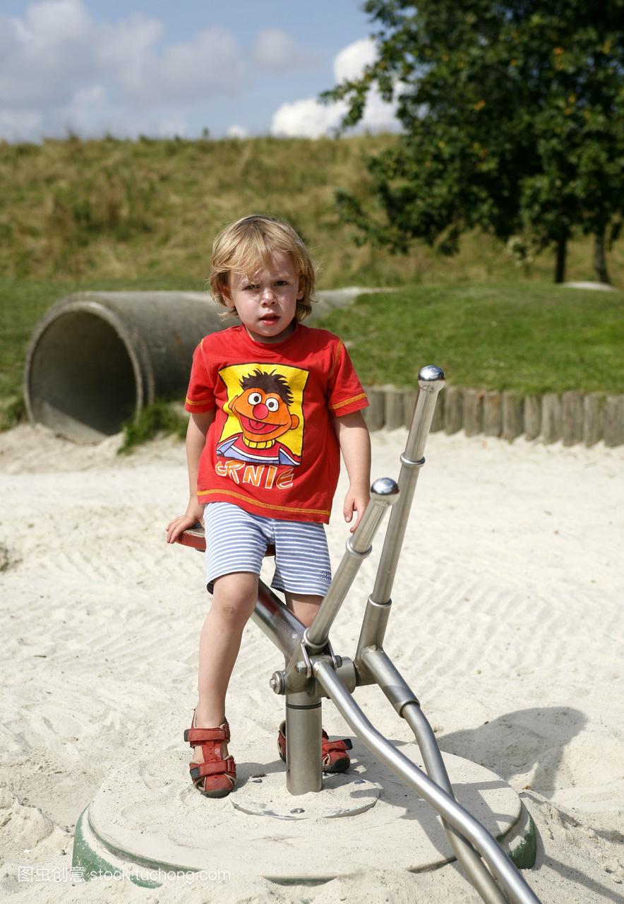 一个三岁的小男孩在一个玩具挖掘机上