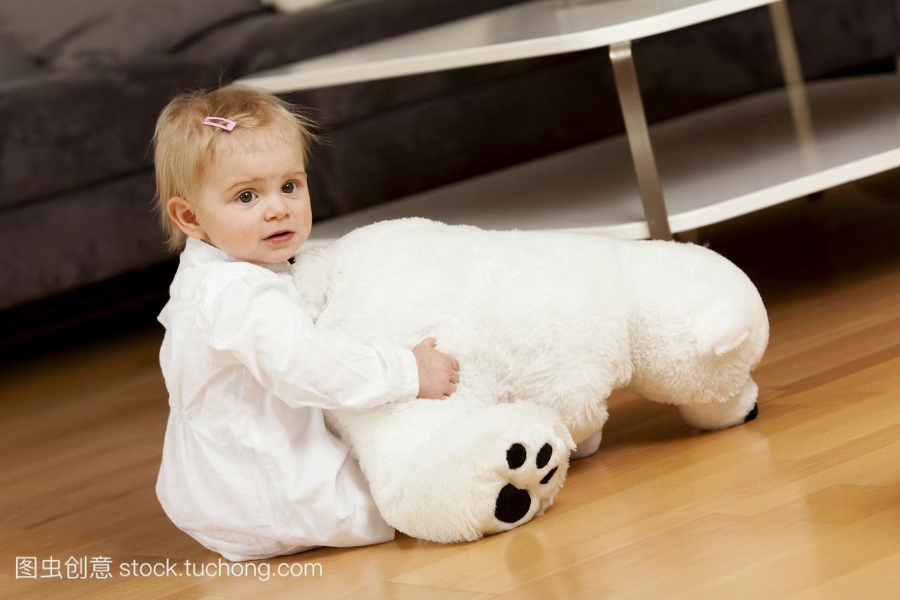 年轻女孩1岁在地板上玩玩具的北极熊