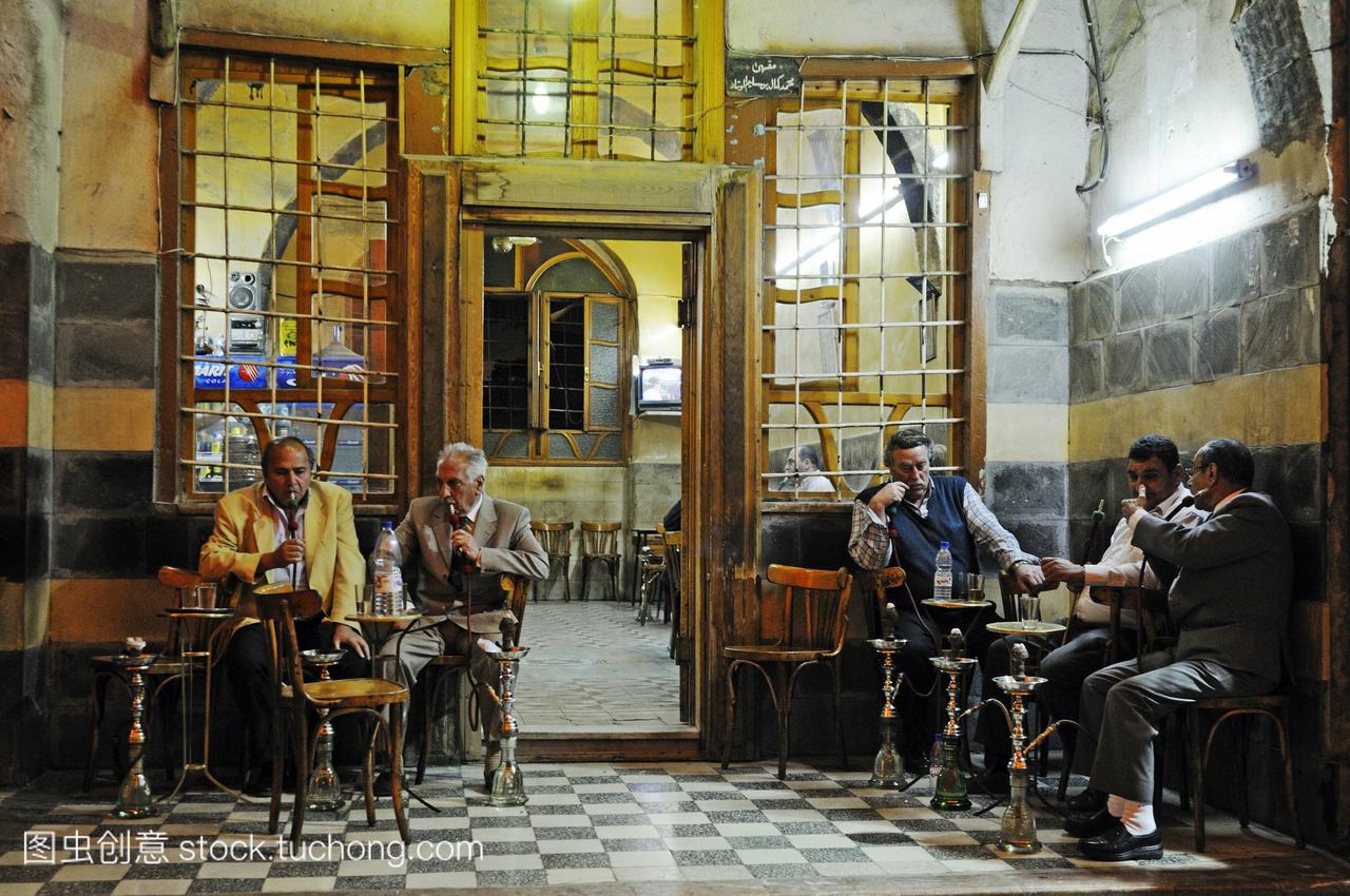 男人抽着水烟在咖啡馆的历史中心集市的大马士