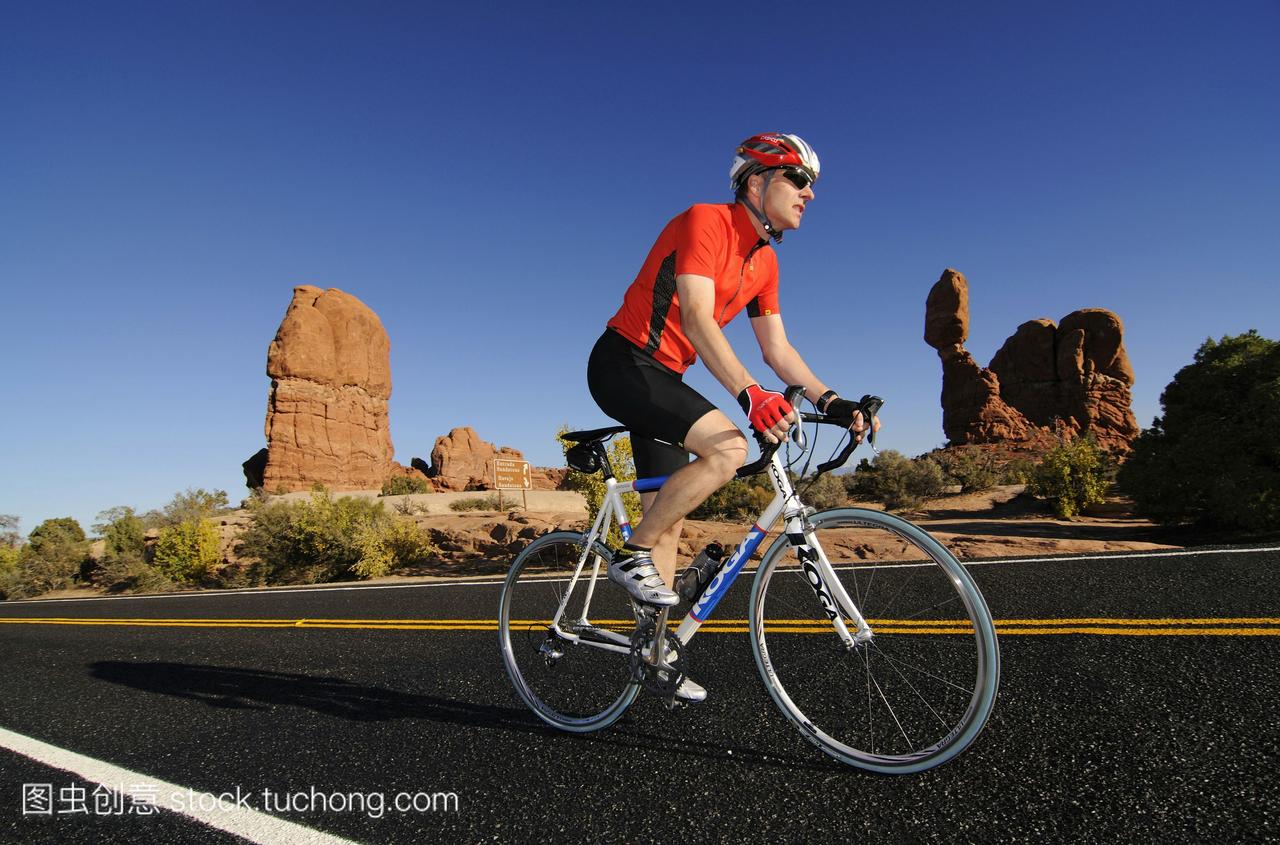 比赛骑自行车平衡的岩石拱门国家公园美国犹他