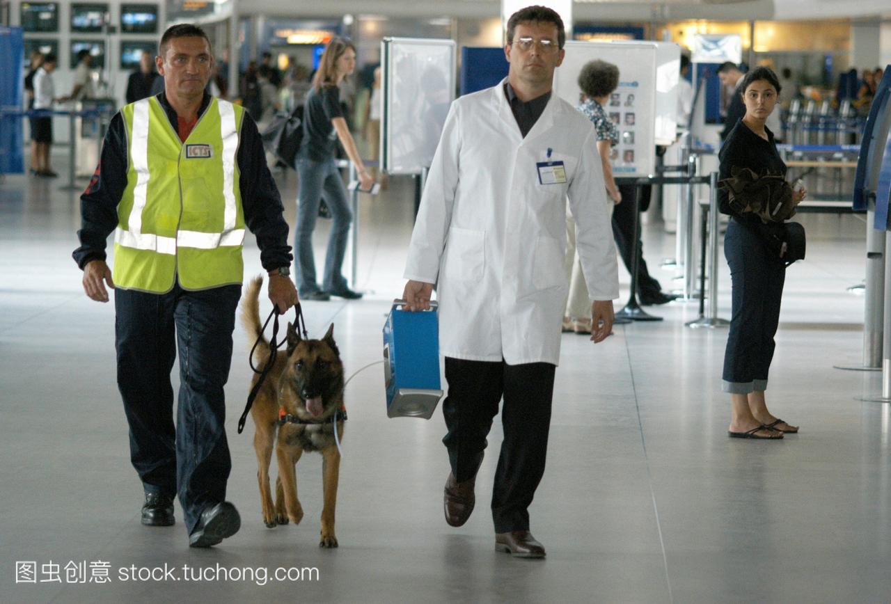 机场安检人员测试了两种类型的监视,一只狗左