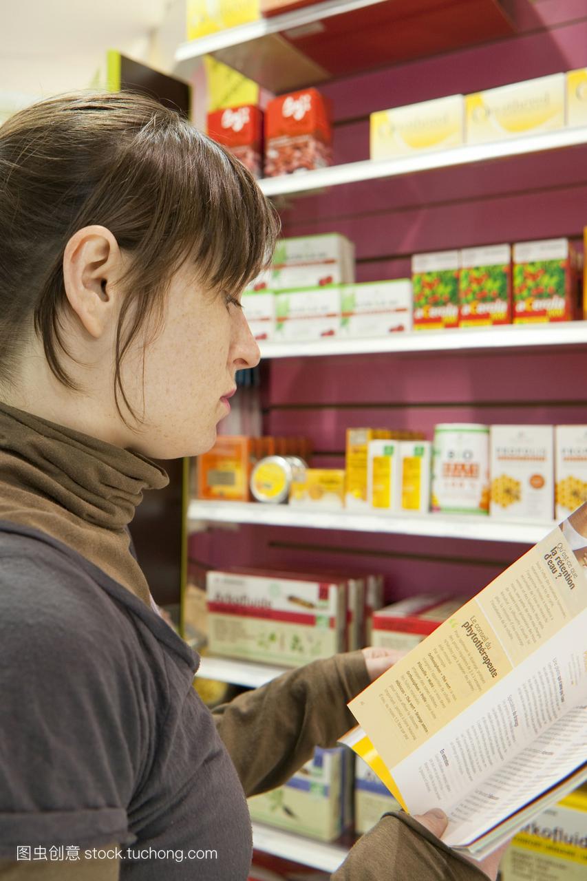 年轻女性在法国巴黎药房购买产品