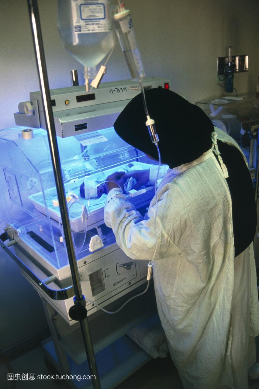 黄疸婴儿治疗。护士照顾新生婴儿在孵育器接受