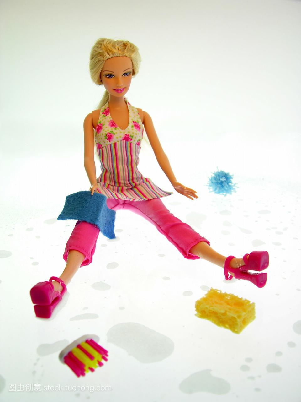 一个金发碧眼的芭比娃娃穿着粉红色的裤子和花