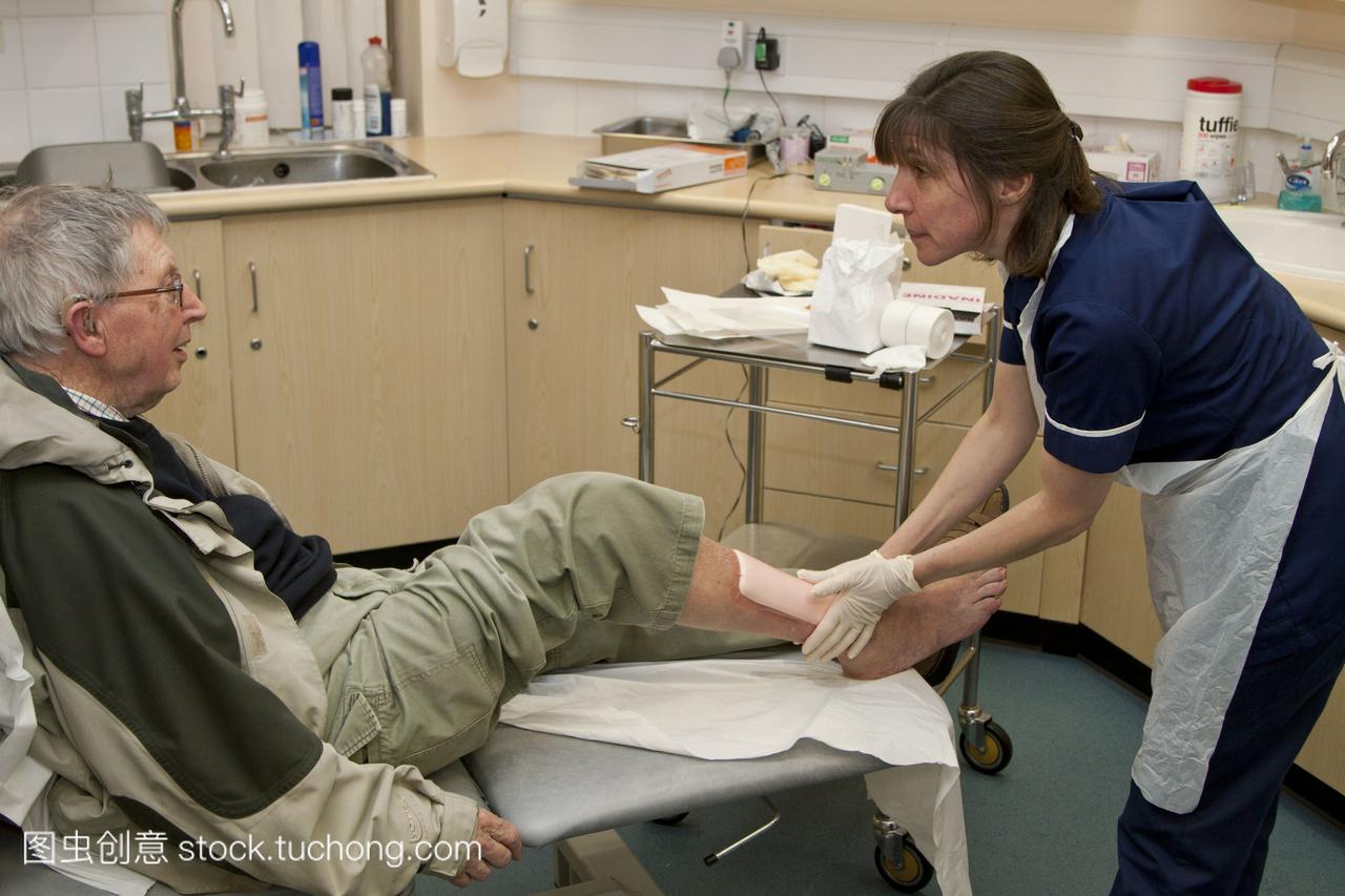 人的腿。练习护士给88岁的男性病人做静脉溃