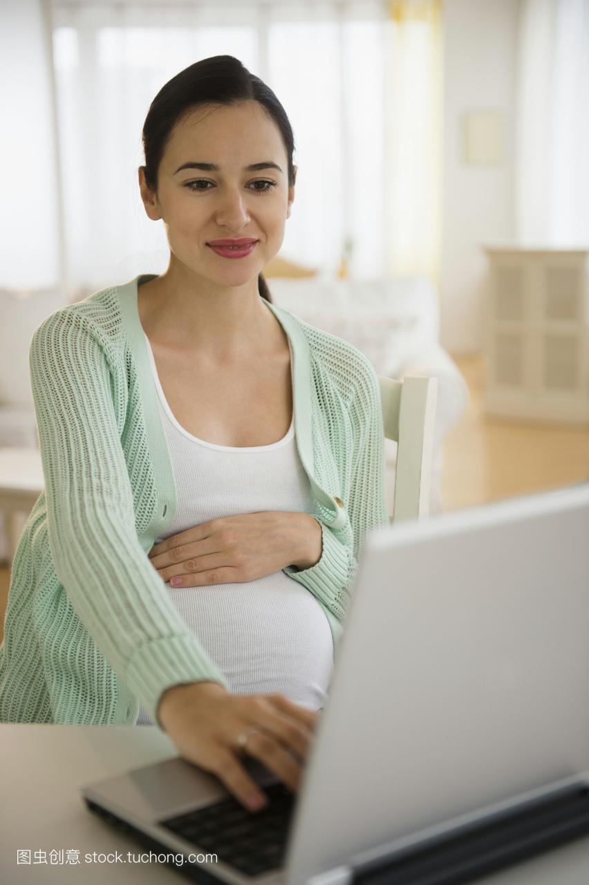 怀孕的白人女性使用笔记本电脑