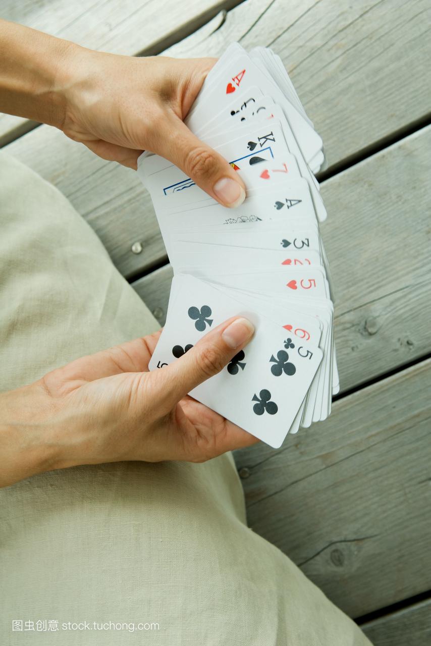 女人手里拿着一副扑克牌,一副很有眼光的