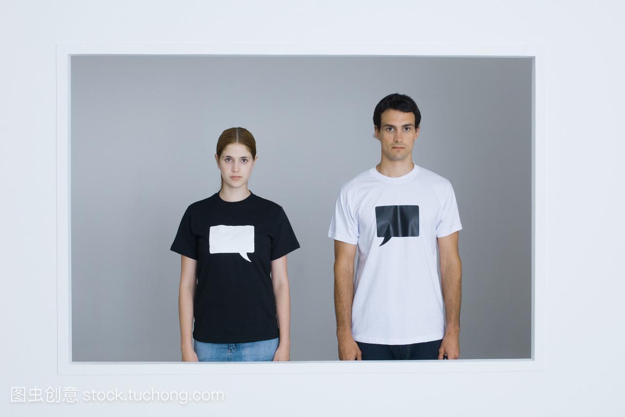 年轻男女穿着印有空白单词泡泡的t恤衫,看着摄
