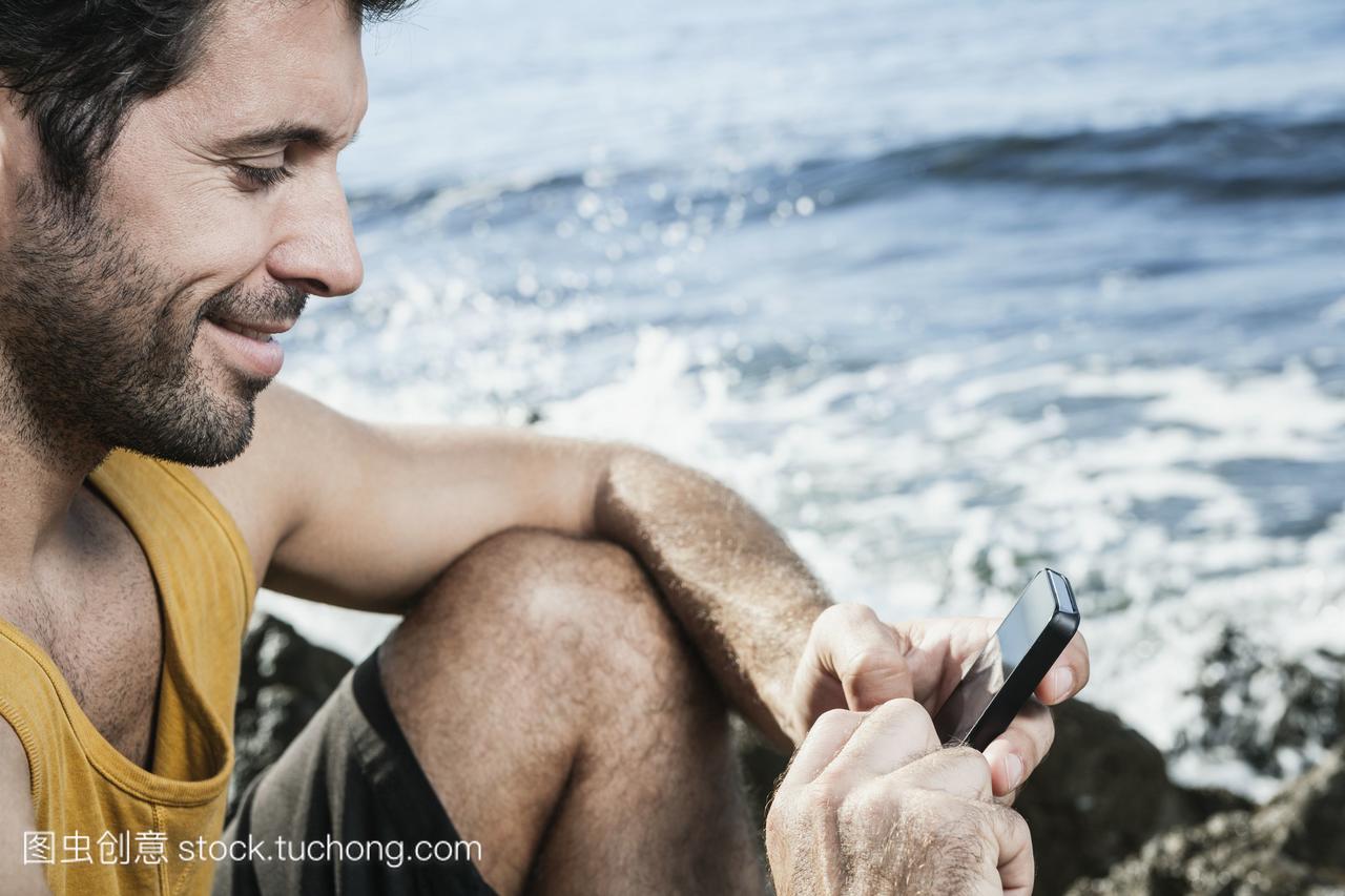西班牙,中年男子用智能手机微笑