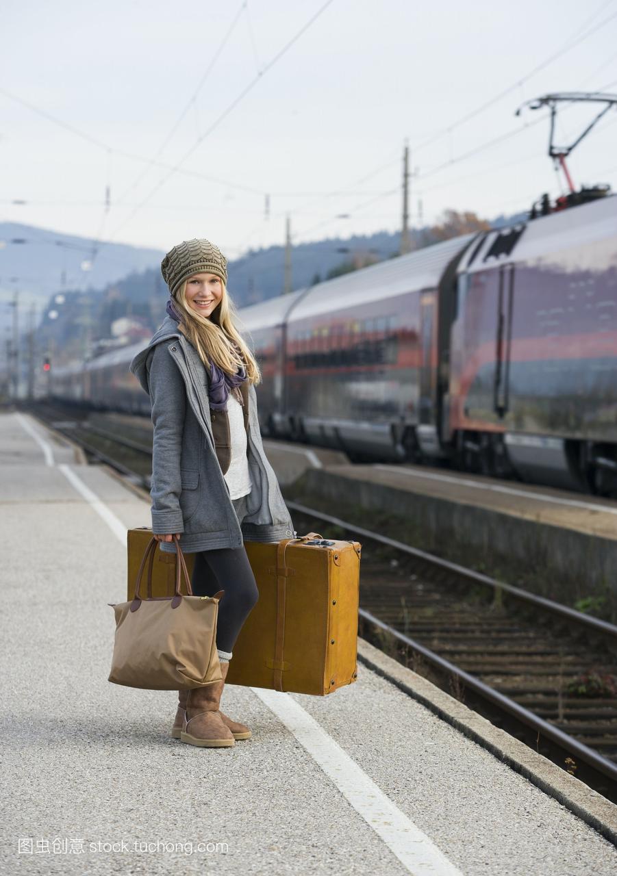 奥地利,一个十几岁的女孩,带着行李箱在火车站