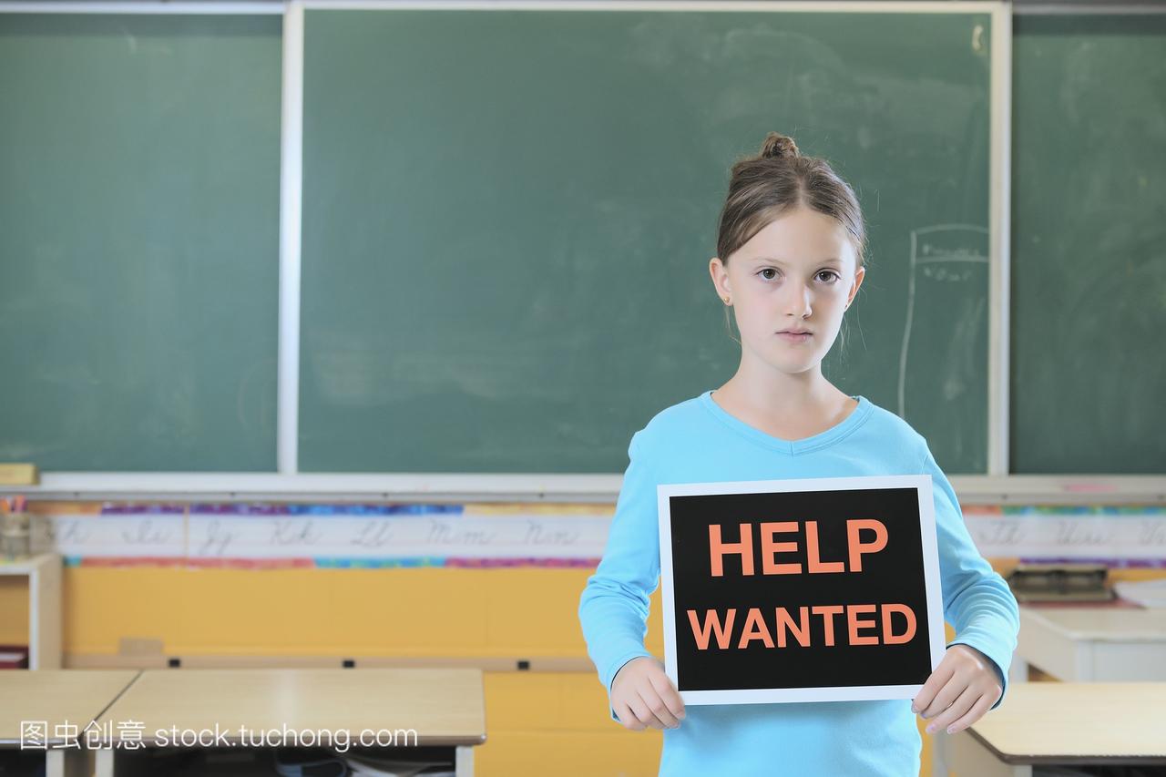 年轻女孩站在教室举行招聘标志;多伦多加拿大