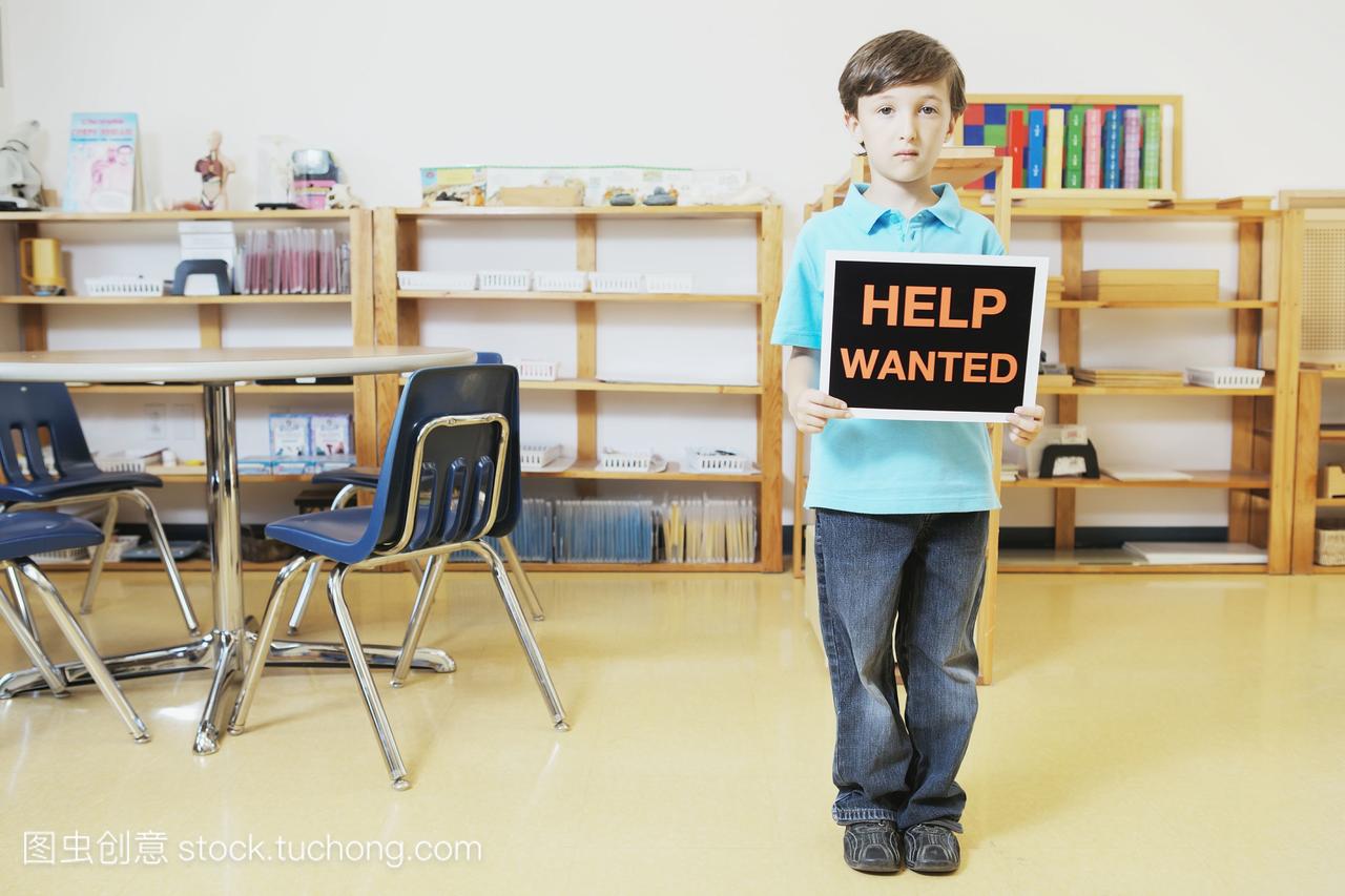 小男孩站在教室举行招聘标志;多伦多加拿大安