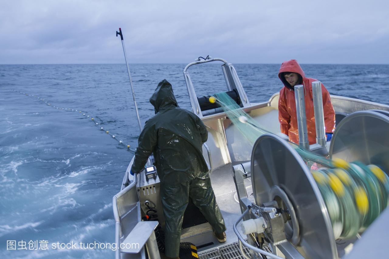 一个商业鲑鱼渔夫在傍晚的光和恶劣的天气下,