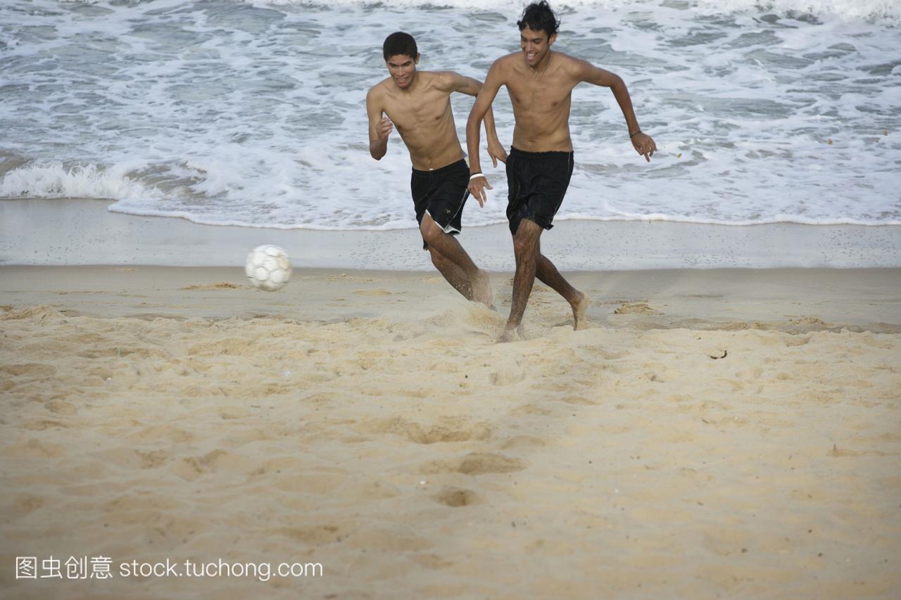 男人在海滩上踢足球巴西