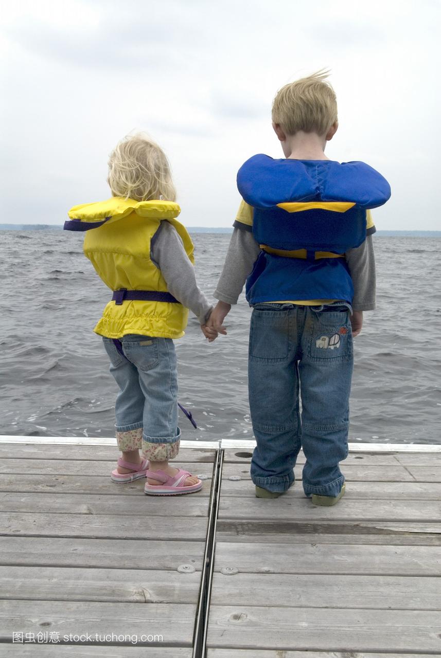 哥哥和姐姐手牵着手在码头救生衣马斯科卡湖布