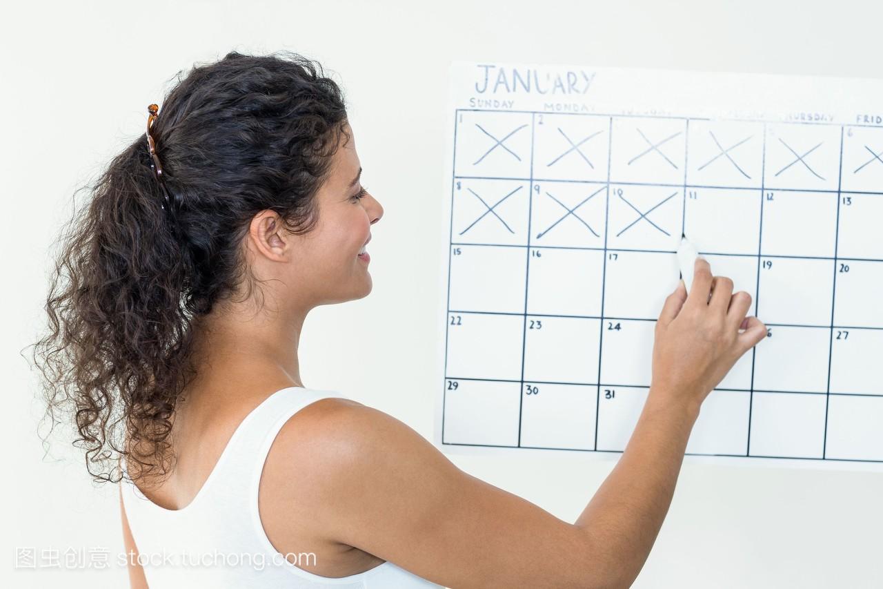 怀孕妇女在日历上标记日期
