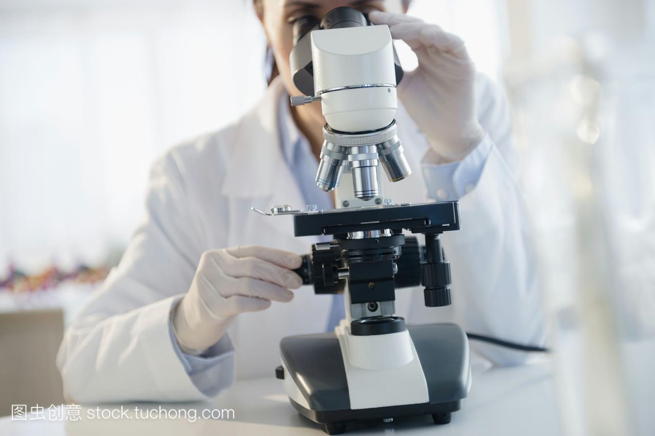混合种族科学家在实验室使用显微镜
